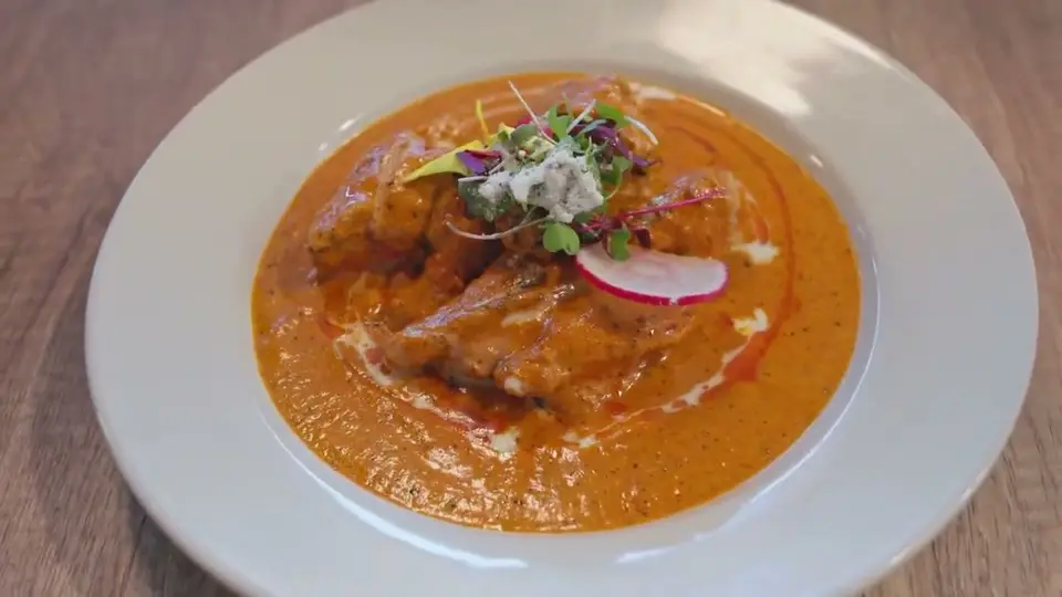 Flames rising from a pan on the stove in the Saffron kitchen