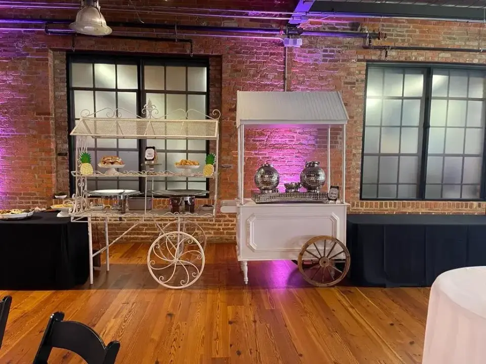 Catering carts set up for a private event in a brick-walled hall